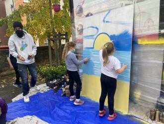Members of YMCA Shine with local artist Stane working on the Town Hall Hoardings