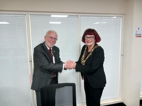 Photo of Cllr barker receiving a handshake off the previous Mayor Cllr Green
