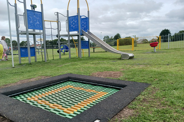 A photo of some play equipment, including a slide and a trampoline