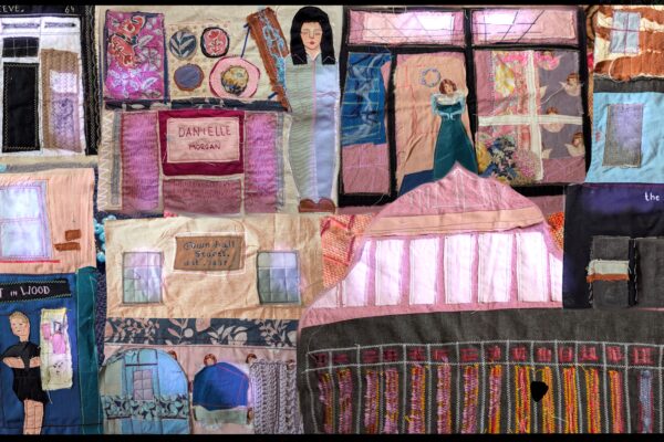 The image shows textile work depicting shop fronts in Lowestoft
