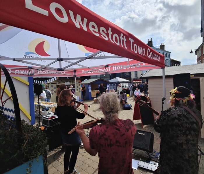 A photo of three musicians standing and playing their instruments