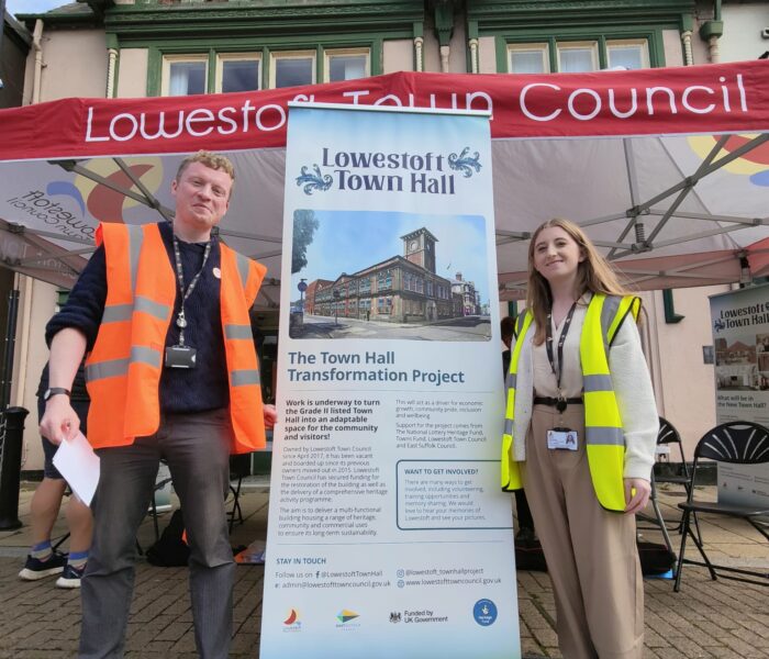 Two people in hi-viz stand either side of a pull-up banner