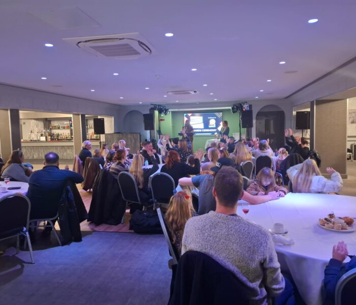 Photo of people sat around tables at an award ceremony