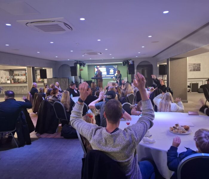 Photo of people sat around tables at an award ceremony