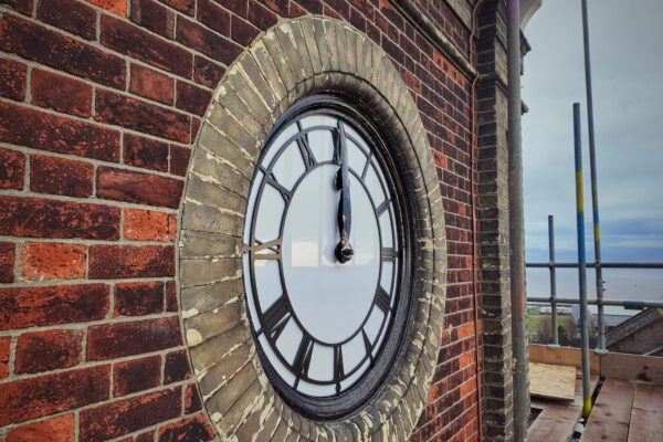 A close up of the clock face. The hands are at 12 'o' clock